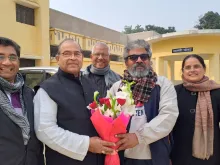 Bishop Louis Mascarenhas of Allahabad greets Father Babu Francis at the gate of Naini jail in Prayagraj district with a bouquet of flowers.