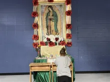 A migrant woman prays in front of an image of Our Lady of Guadalupe at a migrant shelter in McAllen, Texas, run by Catholic Charities of the Rio Grande Valley.