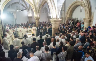 The Catholic faithful gathered in the Cenacle in Jerusalem for the Mass of the Lord's Supper that the Franciscan friars celebrated on Holy Thursday, March 28, 2024. The Cenacle is at the center of strong tensions and disputes regarding ownership and rights of access and celebration. An ancient tradition places King David’s tomb here and over the centuries Jews and Muslims have leveraged this to first expel the Franciscans and then to prevent Christian worship, which they deemed sacrilegious. Credit: Marinella Bandini