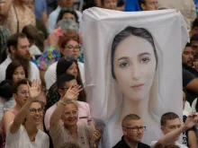 Pilgrims at the Wednesday general audience Aug. 9, 2023, hold up an image of the Virgin Mary.