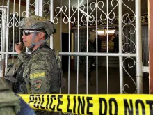 Military personnel stand guard at the entrance of a gymnasium while police investigators look for evidence after a bomb attack at a Catholic Mass at Mindanao State University in Marawi, Lanao del sur province in the southern Philippines on Dec. 3, 2023. At least three people were killed and seven wounded, officials said.