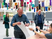 A man receives his ballot for the European elections in a polling station in The Hague on June 6, 2024, on the first day of the European Parliament election.