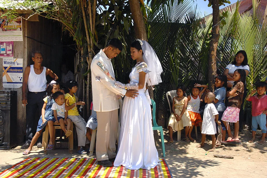 Filipino newlyweds dance in the street during a reception in Baleno town, Masbate island province in the central Philippines, April 15, 2007.?w=200&h=150