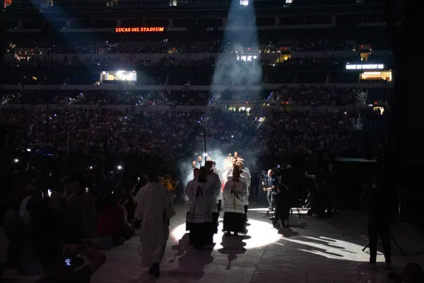 Father Boniface Hicks, OSB, a sought-after spiritual director and retreat master, processes the massive golden monstrance containing the Eucharist into the midst of the assembled crowd in Lucas Oil Stadium. Credit: Jonah McKeown/CNA