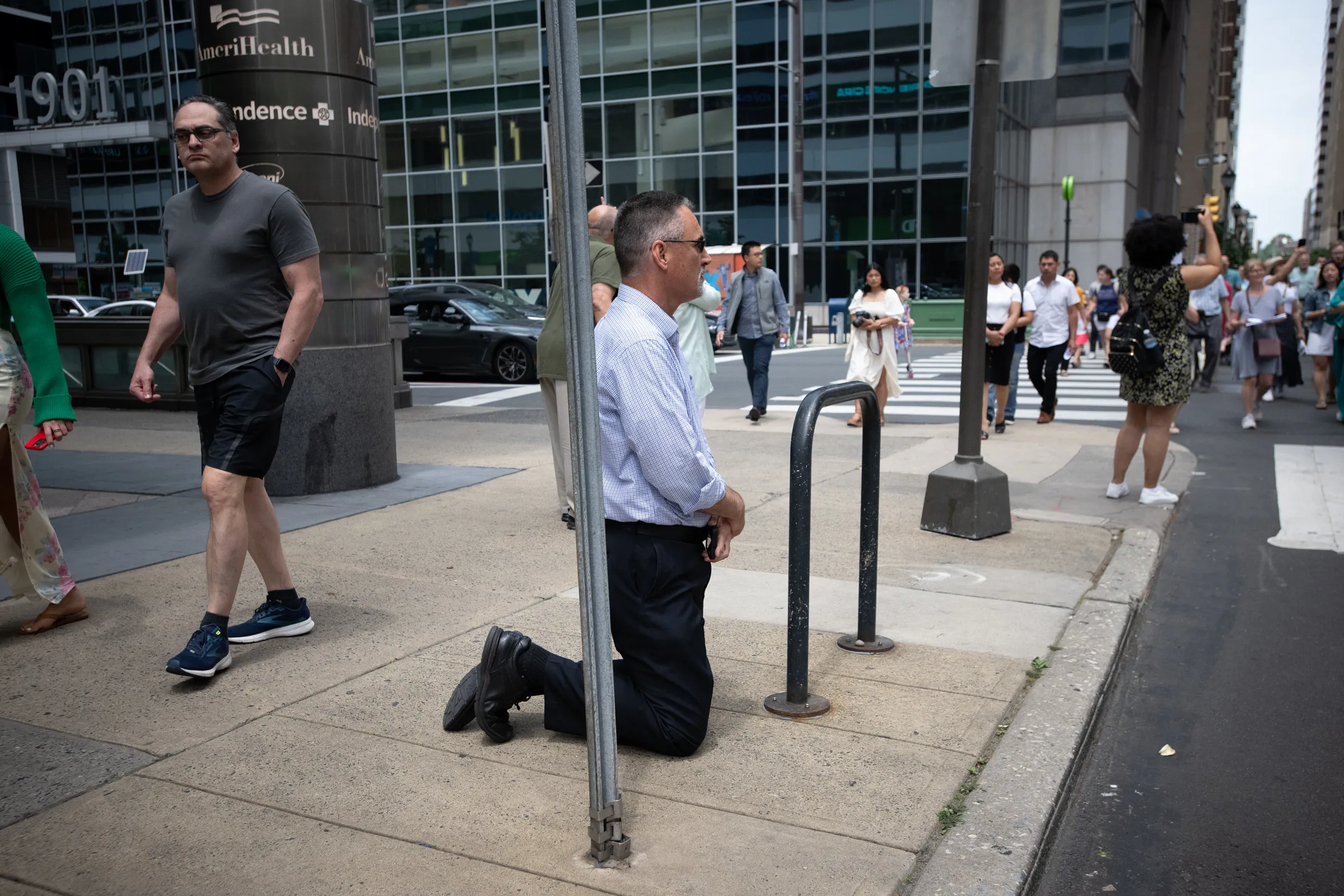 A man kneels as the National Eucharistic Procession passes by in Philadelphia on May 30, 2024.?w=200&h=150