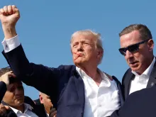 Republican presidential candidate former President Donald Trump pumps his fist as he is rushed offstage during a rally on July 13, 2024, in Butler, Pennsylvania.